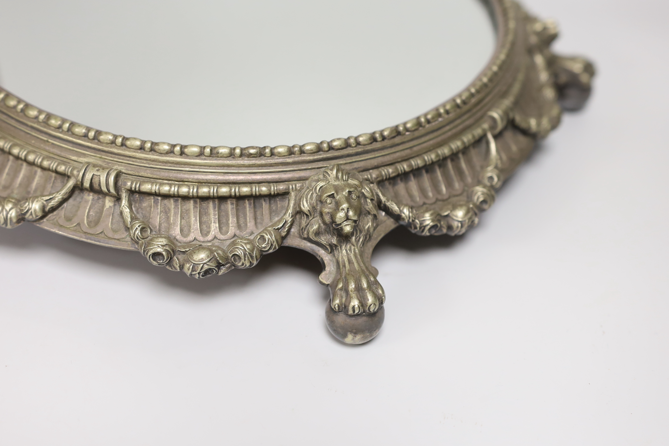 An electroplate mirrored plateau or cake stand decorated with lions and swags, 36cm in diameter